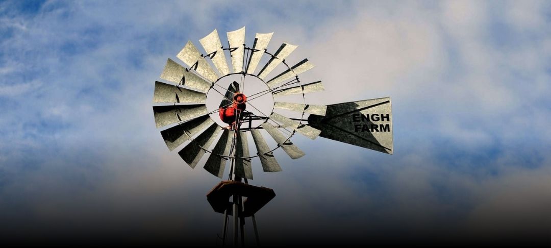 A windmill in Sycamore, Illinois, stands tall against a partly cloudy sky, capturing a rustic charm